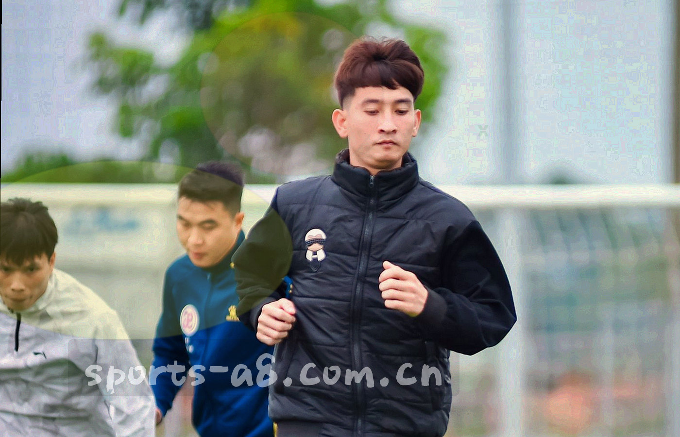夜间办公环境中多块屏幕显示赛事数据界面，以屏幕光为主要光源，值守人员仅以剪影出现
